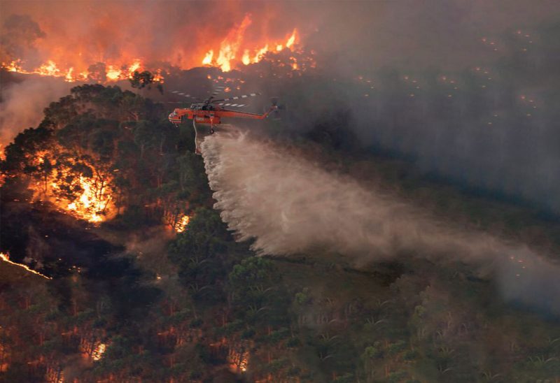 A helicopter tackles a wildfire in East Gippsland, Victoria state, Australia. Wildfires burning across Australia's two most-populous states trapped residents of a seaside town in apocalyptic conditions Tuesday, Dec. 31, and were feared to have destroyed many properties and caused fatalities. (State Government of Victoria.)