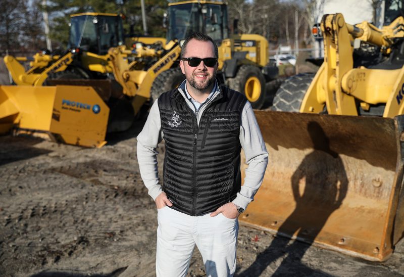 Mark Aquilino stands in the equipment yard — the single tractor and dump truck replaced now by 50 loaders, 50 skid-steers, 50 plow trucks, more tanker trucks for brine and some 50-60 pieces of equipment for clearing snow from walkways. (Photo by Cheryl Senter.)