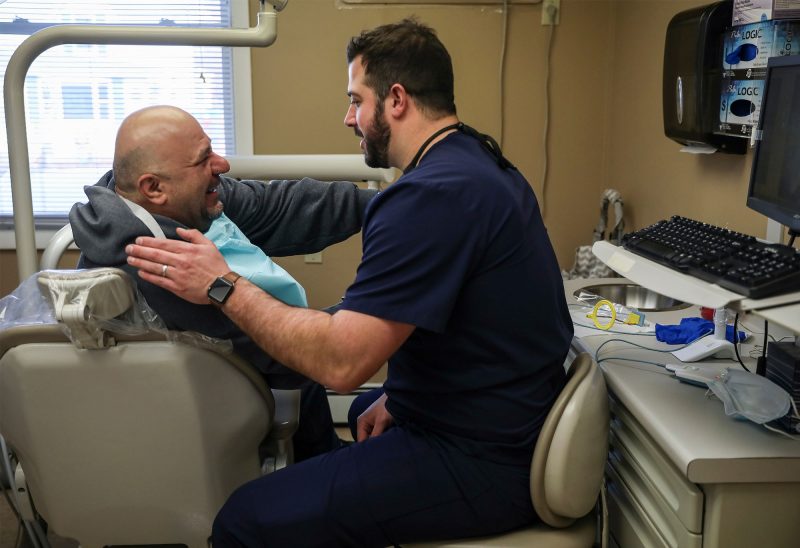 Dr. Kyle Prohovich, Greater Nashua Dental Connection’s full-time staff dentist with patient David Ivanoff. (Photo by Cheryl Senter.)