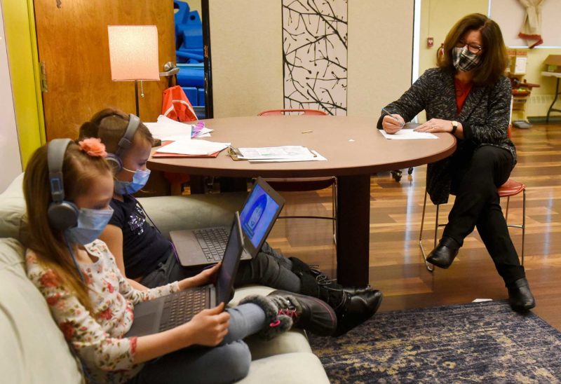 Sharron McCarthy, CEO, looks on as sixth-graders Jaelyn Hartford, left, and Kianaly Gallego participate in the after-school youth enrichment activity at Girls Inc. in Manchester in January. (Photo by Union Leader Photographer Thomas Roy. Used with permission.)