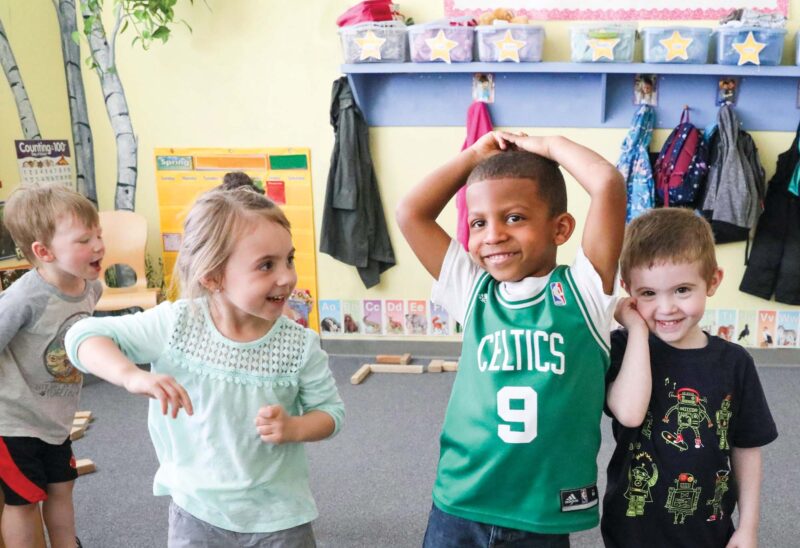 Four happy children in a classroom