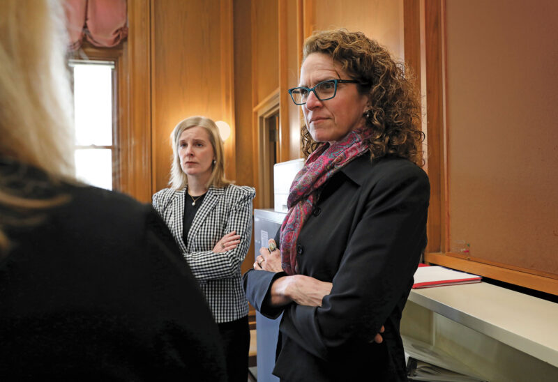 Laura Milliken (right) speaks with colleagues at the Legislative Office Building in Concord, NH. (Photo by Cheryl Senter.)
