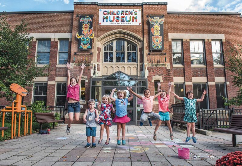 Children jumping in front of the Children's Museum of New Hampshire. (Photo by TARA Photography.)