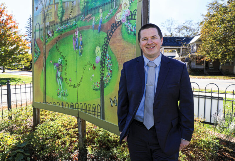 Cody Morrison, executive director of the Monadnock Economic Development Corporation , stands in front of a mural